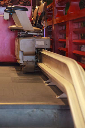 Disabled lifts provides this comfort by its platform attached to the corner of the stairs when disabled persons go up or down. Building Accessibility Design, Stair lift for Handicapped persons conceptの写真素材