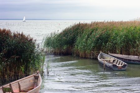 Sailboat against a background of fishing boatsの写真素材