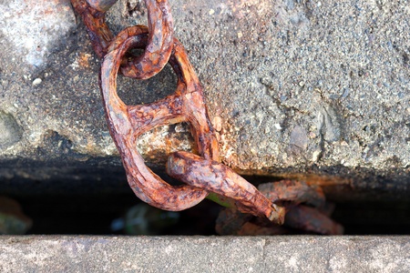 The old chain was stuck at the pier in concrete blocksの写真素材