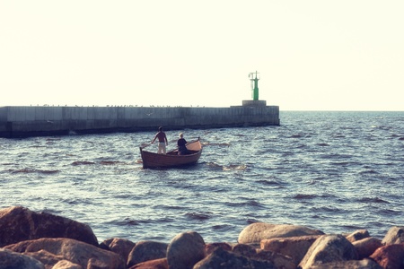 Couple goes to sea in a boat at the lighthouseの写真素材