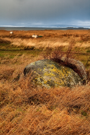 Old stone split and boat on the beachの写真素材