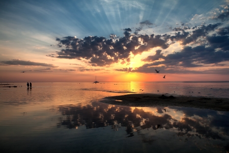 Couple walking on the beach on the sea at sunsetの写真素材
