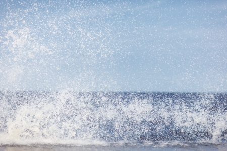 Spray from the waves on the background of sky and seaの写真素材