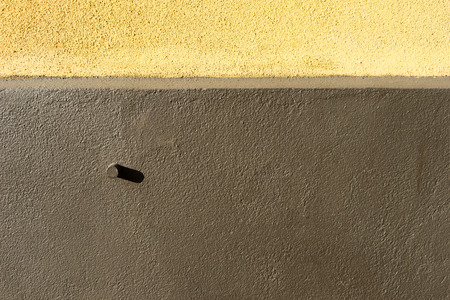 Wall of the house in yellow and brown with a shade of boltの写真素材