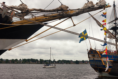 Sailboats with flags at the pier and yacht during a regatta in Riga on the Daugava