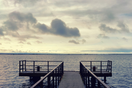 Empty pier by the sea on a background of clouds in early spring. Baltic sea