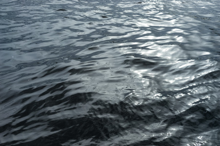 Light waves on the water at night with glare from sunlight