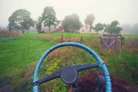 Blue electrical tape on the steering wheel of the car on the background of the rural house in the fogの写真素材