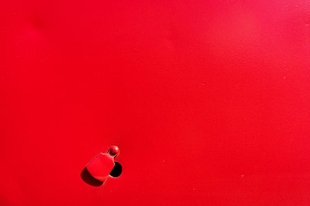 Latvia, Riga. July 2015. Red painted metal with a hole and a plug for the key from the doorのeditorial素材