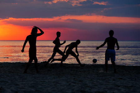 Latvia. Silhouettes of young players with a ball on the beach of the Baltic Sea at sunsetの写真素材