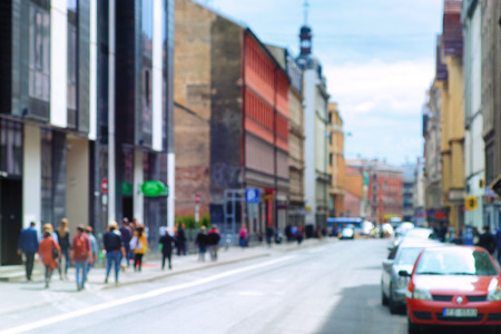 People walk on the street with cars in the European city of Riga on a sunny summer day. Blurryの写真素材