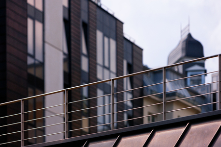 A fragment of the modern building with handrail lines and planes of the windows in the neighborhood with old houses with turrets. Rigaの写真素材