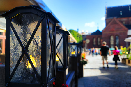 A pair of summer is on the town square past the cafe with light candles in decorative lampsの写真素材
