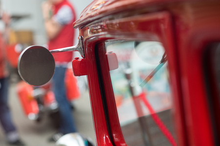 Red vintage car and a man in a motorcycle on the background of mirrorsの写真素材