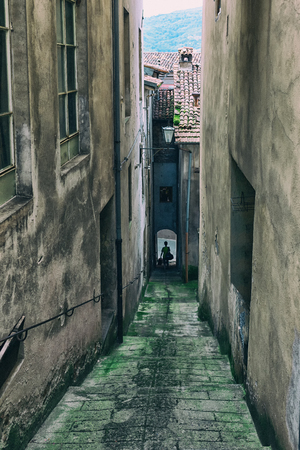 Pedestrian is walking on the stairs of the narrow streets between the houses in a small Italian townの写真素材