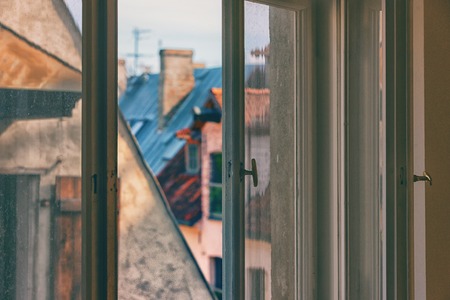 Open window overlooking the roofs of old Riga in the vertical lines of the valvesの写真素材
