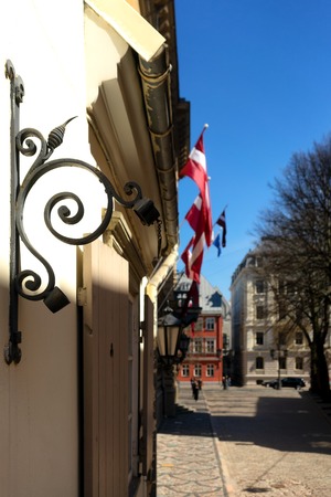 At home with national flags on the street of old Riga in the holiday by Parliament in the springの写真素材