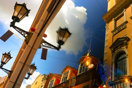 Reflection of the blue sky and facades of old houses with street lights in a summer sunny day. Rigaの写真素材