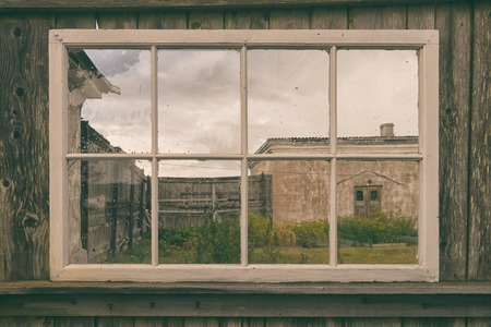 A glance through the window to the old fishing yard under the cloudy sky on the shore of the Baltic...の写真素材