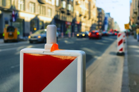 Red with white fence repairing road in downtown le...の写真素材