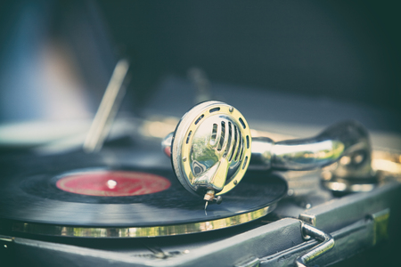 Vintage gramophone with a needle on a black plate with a red stickerの写真素材
