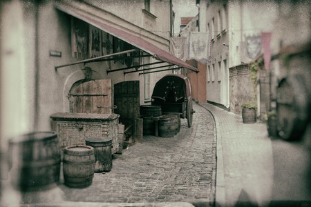 Stylized medieval installation with a cart and wooden barrels on the background of flags in old Rigaの写真素材