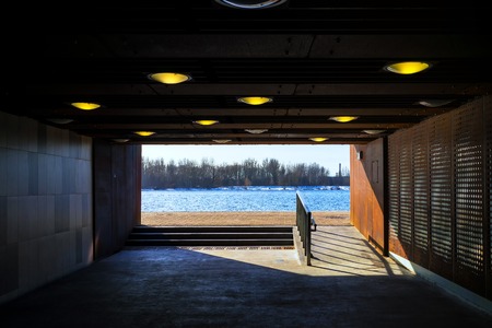 River with trees on the shore in the spring in the passage of the tunnel with yellow lampsの写真素材