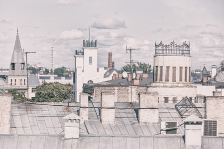 Different roofs of houses with pipes and antennas of Riga on a sunny dayの写真素材