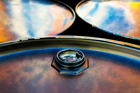 Black closed barrels with the reflection of clouds in the sky on the lids with dust like stars