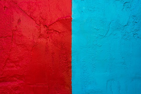 Textured wall painted in red and turquoise bright and contrasting colorsの写真素材