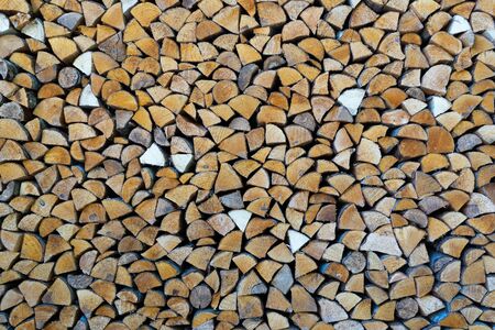Chopped logs of firewood harvested for the winter and stacked under the roofの写真素材