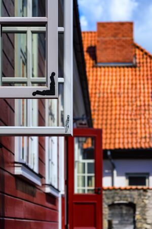 Open windows and doors of an old red wooden house on a hot summer dayの写真素材