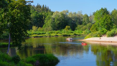 Boat sways on the waves of the river Gauja in Latvia on the background of a hammock on the shore