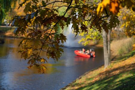 Red boat on a city canal in Riga on an autumn sunny dayの写真素材