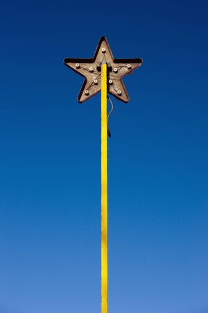 A metal star on a yellow pole on the back. Instead of a bright front, we see the inside out. Wire and mounting basesの写真素材