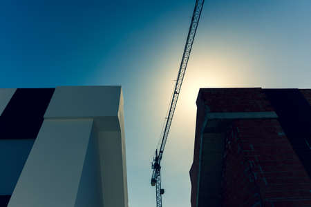 New houses are being built on the Mediterranean coast. Tall construction crane against the backdrop...