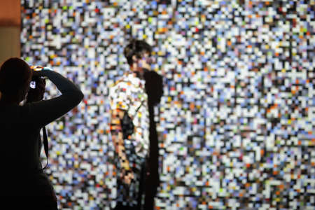 The man on the background of the projection of colored pixels. Pixels are chaotic in shape and color. The man on the background of the projection of colored pixels. Pixels are chaotic in shape and color. The girl takes pictures on a SLR camera and the pixels are visible in the displayの写真素材