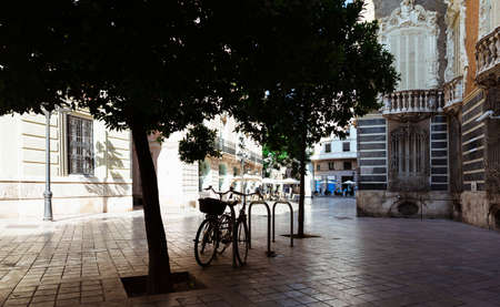 Summer sunny day on the street of Valencia. Shade from trees on bicycles. People are resting in a cafe. Spainの写真素材