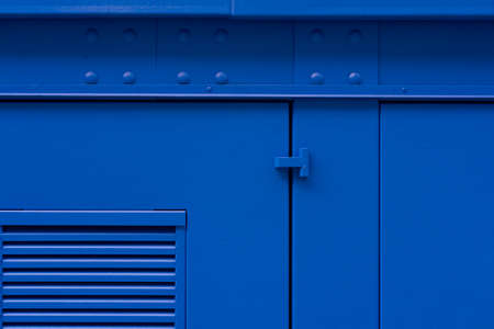 Blue painted iron wall with doorの写真素材