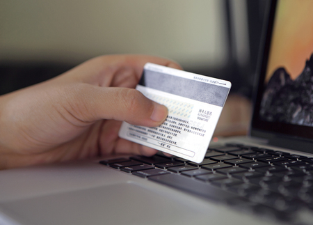 Hands holding credit card and laptopのeditorial素材