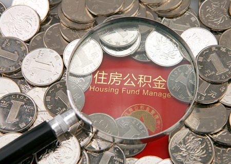 A lot of coins and magnifier on the background of housing accumulation fund bankbookのeditorial素材