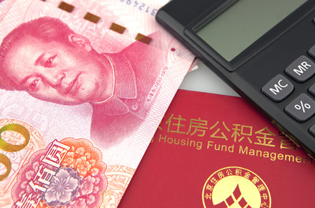 Chinese banknotes,calculator and housing accumulation fund bankbook on white backgroundのeditorial素材