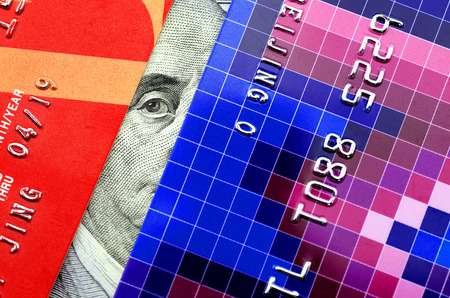 Credit card and one hundred dollars banknote.Franklin peep between two credit cardsのeditorial素材