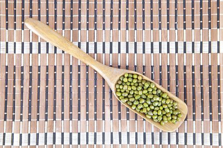 A spoonful of green beans on a bamboo matの写真素材