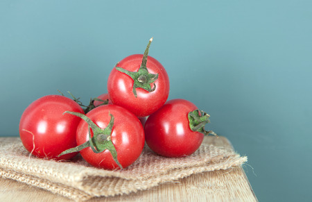 A pile of tomatoes in front of a green backgroundの写真素材
