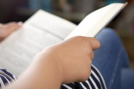 Close up view of a girl holding a book in handの写真素材