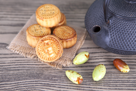 A teapot and moon cakes on the wooden tableの写真素材