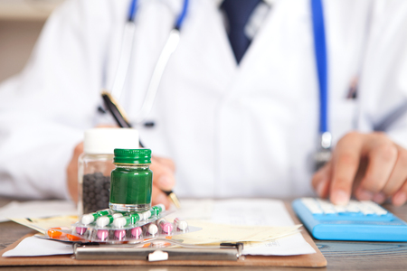 A doctor calculating the price of a drugの写真素材