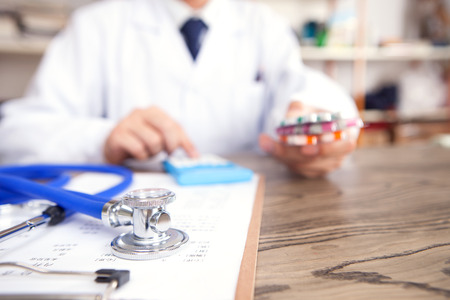 A doctor calculating the price of a drugの写真素材