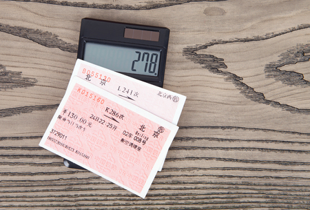 Train tickets and calculator on wooden backgroundのeditorial素材